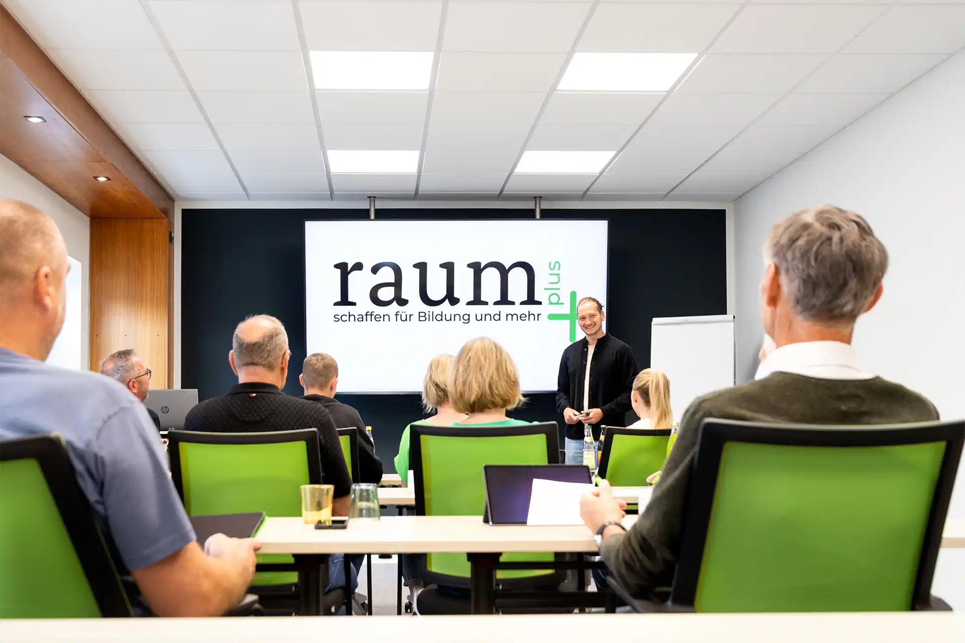 raumplus-schulung Raumplus+ Logo auf dem Präsentationsbildschirm im Seminarraum
